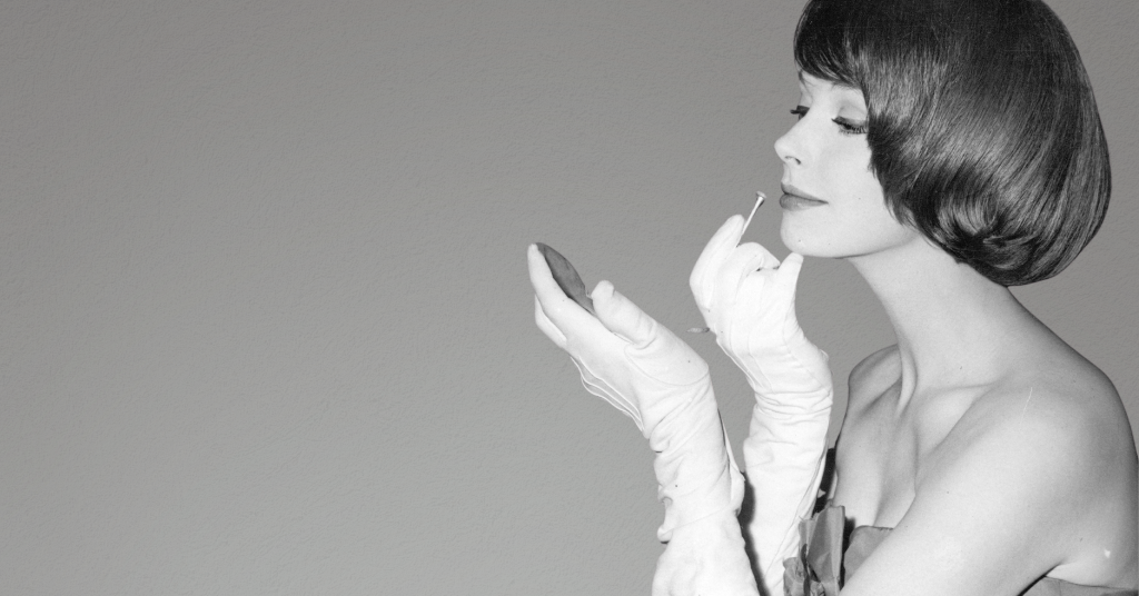 Woman putting on lipstick admiring the benefits of a nano-peel