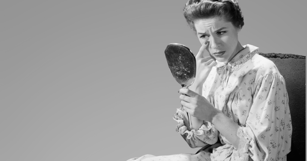 Woman looking into mirror considering cosmetic injections