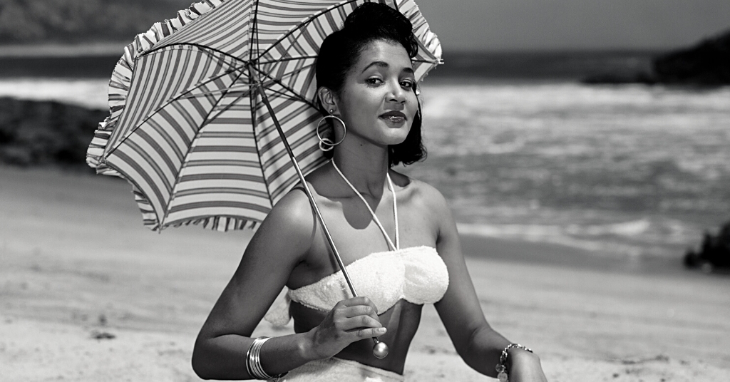 Woman at beach in bathing suit after breast revision surgery (model)