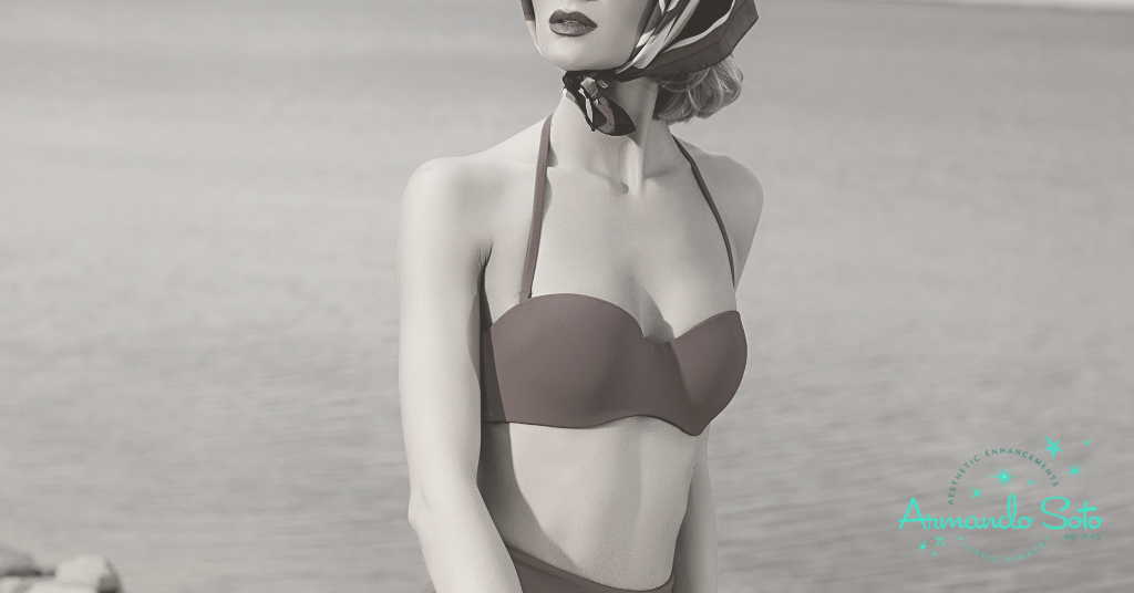 image of woman contemplating her breast augmentation recovery at the beach (model)